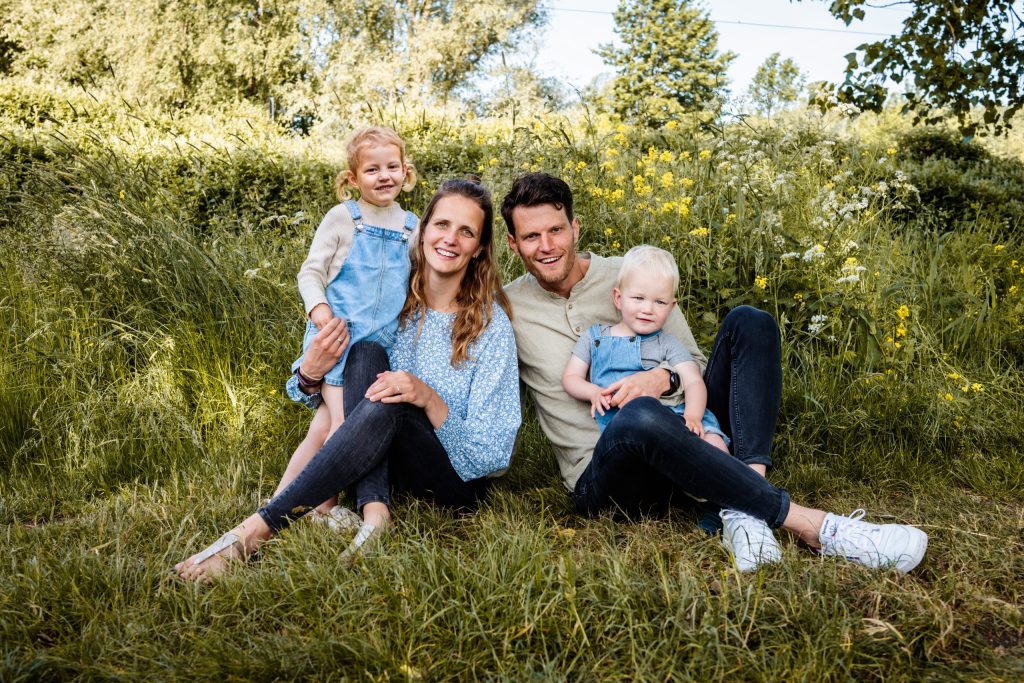 Jong gezin met twee kleine kinderen in het hoge gras