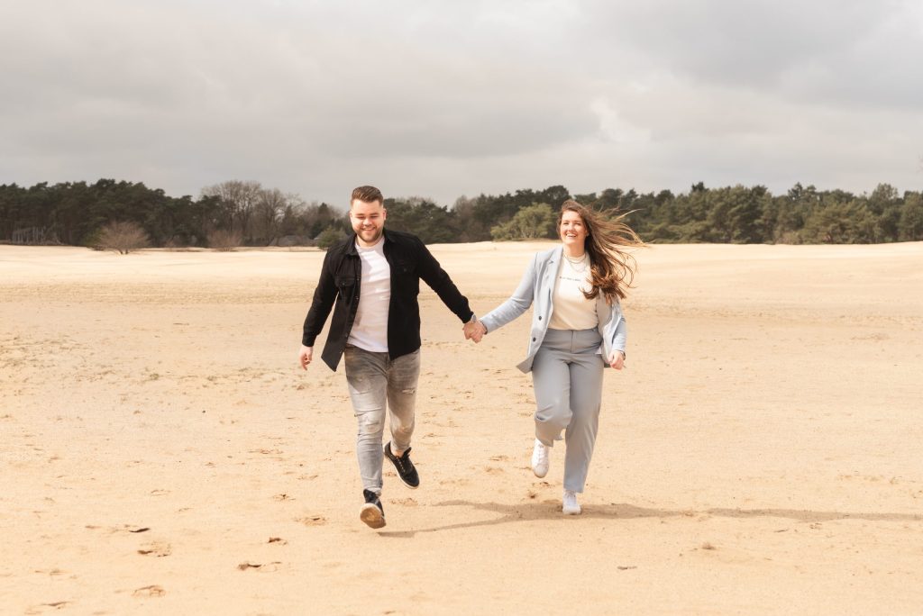 Stel loopt hand in hand over het strand