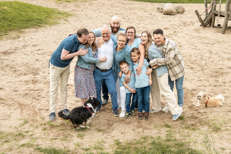 Familie poseert ontspannen in een groene omgeving
